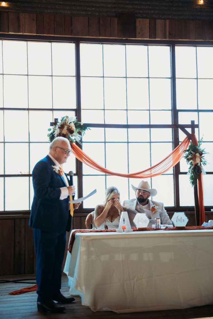 Texas Wedding Host Daryoush Ghashghai Hosting bilingual wedding ceremony in Texas with bride and groom seated at the head table